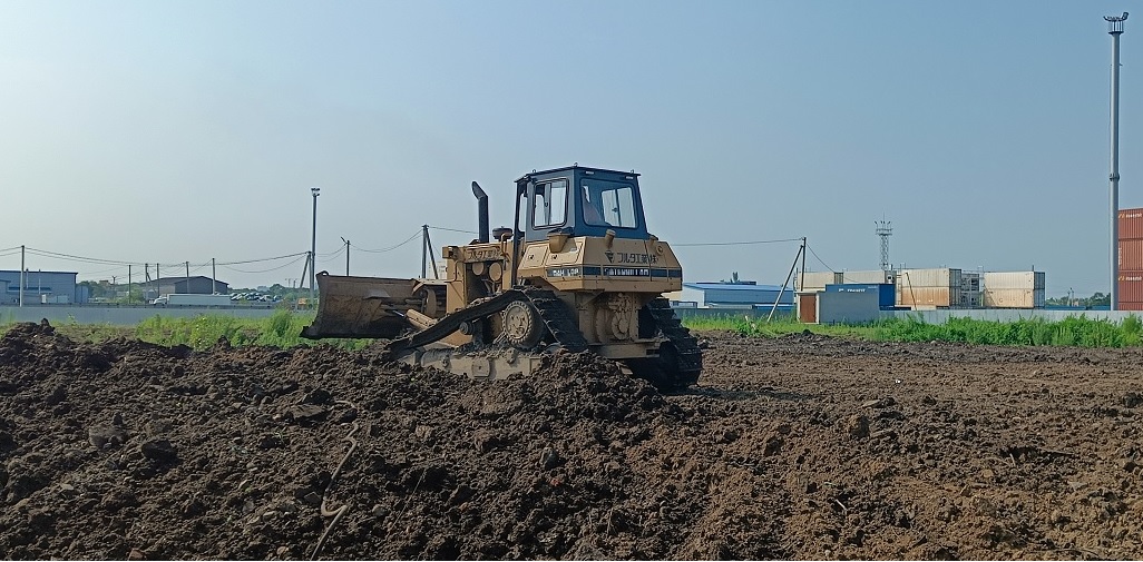 Бульдозер и экскватор роют и копают котлованы в Суворове